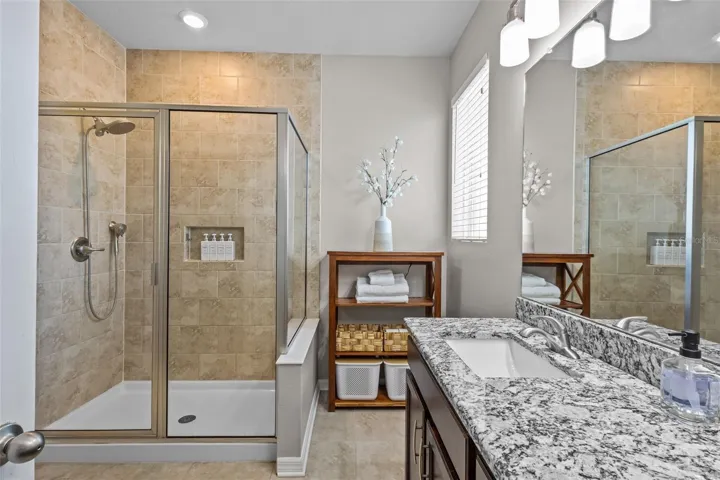 Primary bathroom features dual sinks, granite countertops, and a walk-in shower.