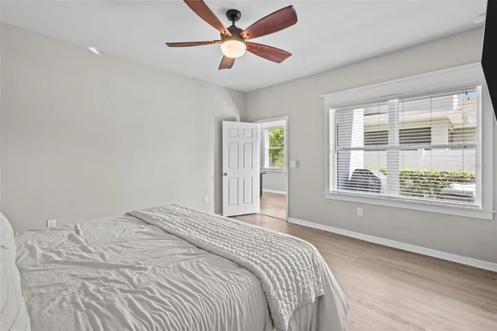 First-floor primary suite features upgraded flooring and custom wood window trim