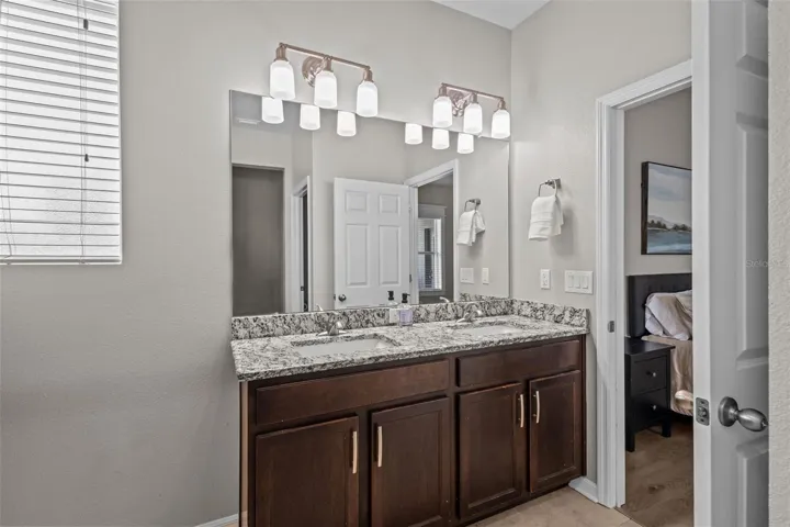 Primary bathroom features dual sinks, granite countertops, and a walk-in shower.