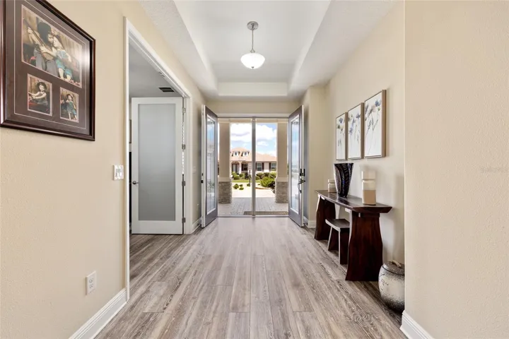 Welcoming foyer featuring a tray ceiling and seamless LVP flooring throughout.
