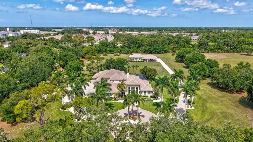 Tucked away on a 5.1 acre lot surrounded by native vegetation withgrounds secured by fencing and a gated driveway.