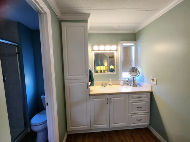 master bath vanity with linen closet is separate from shower room and commode