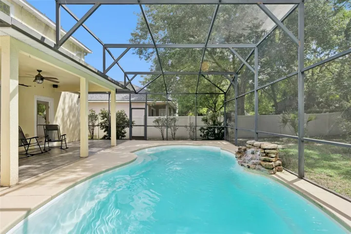 The waterfall feature adds a resort-style atmosphere to the backyard retreat.