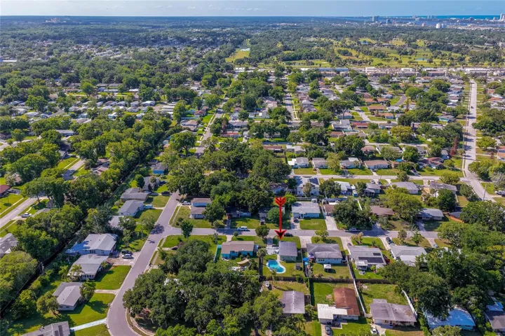 Wide-angle regional aerial highlighting the home's proximity to surrounding coastal areas, golf courses, and local community amenities.