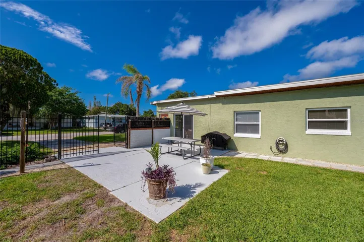 Fenced-in backyard highlighting a secure gated entry and low-maintenance green spaces.