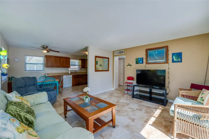 Bright, open-concept living room featuring tile flooring and a clear view into the adjacent kitchen and dining area.