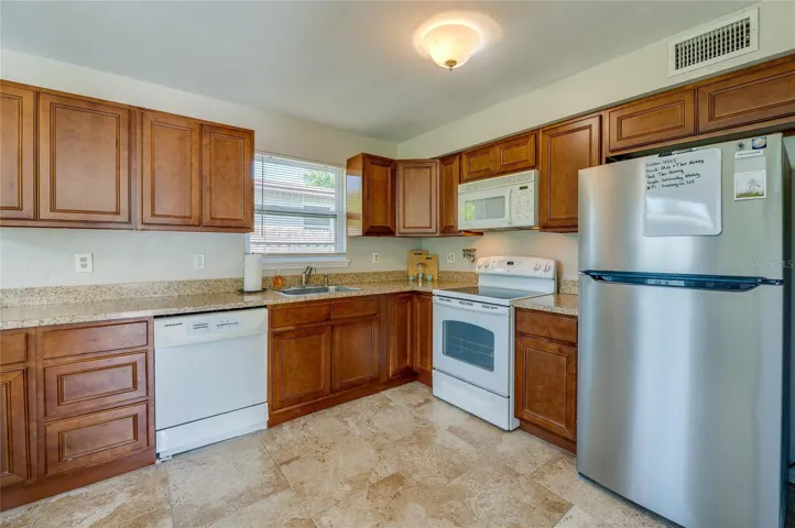 Fully equipped, efficient kitchen showcasing ample countertops and classic wood cabinets.