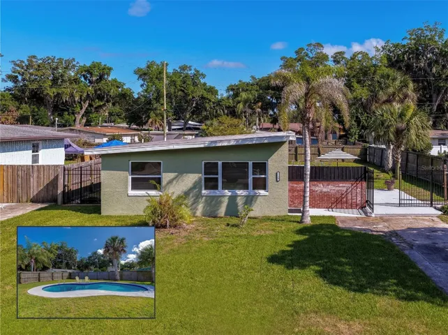 Charming 1-story home with modern design with spacious fenced yard, private pool, and tropical landscaping with mature palms and a bright, open outdoor setting.
