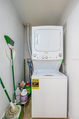 Convenient laundry niche utilizing a space-saving stacked washer and dryer unit alongside dedicated storage for household cleaning supplies.