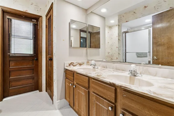 2nd bathroom with double sinks, linen closet and door to the back yard