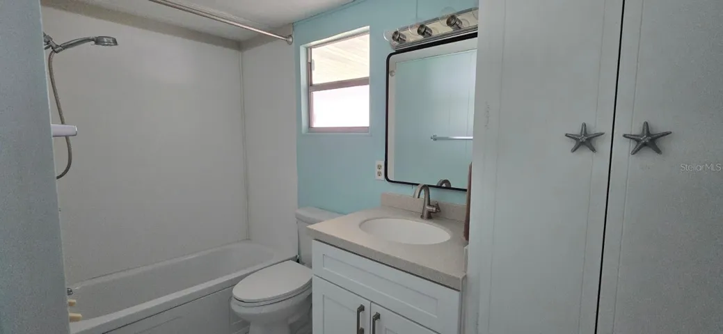 BathroomUpdated bath with new white shaker vanity, Corian countertop, new fixtures, full tub/shower, and those fun coastal starfish pulls that tie the whole home together.