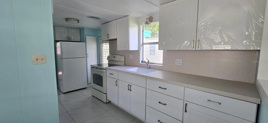 KitchenFully renovated kitchen with brand new white shaker cabinets, updated countertops, new sink and faucet, stylish lighting, and all appliances included.