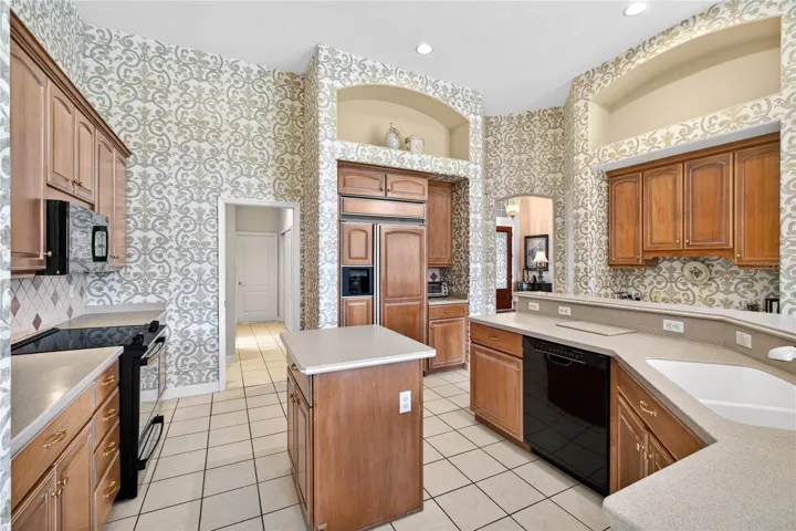 The well equipped spacious kitchen features solid wood cabinetry with solid surface countertops.  Range, dishwasher and microwave replaced 2021.