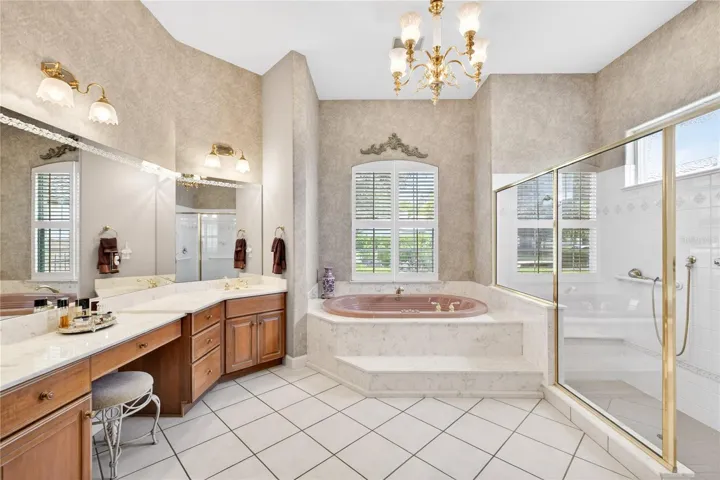 The primary bathroom features dual vanities and dressing table.  Start your day in large garden tub or the large walk-in shower.