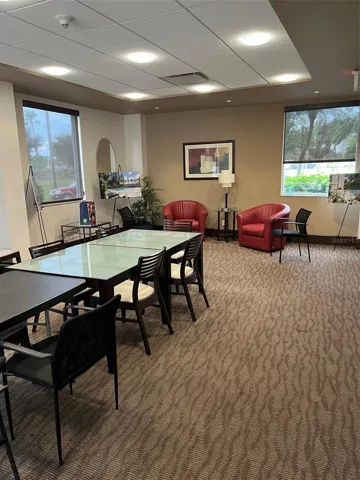 Socializing, meeting, and Entertainment room. Expands through doors to Pool Patio with tables outside.