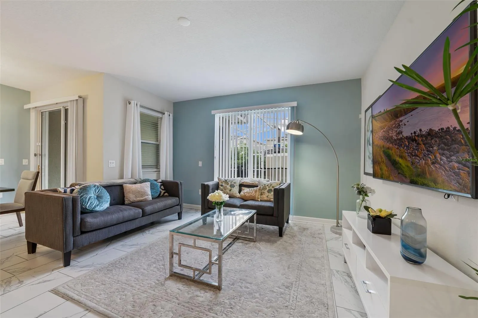 The main living spaces feature beautiful MARBLE-LOOK CERAMIC TILE FLOORING throughout, creating an elegant and easy-to-maintain living space.