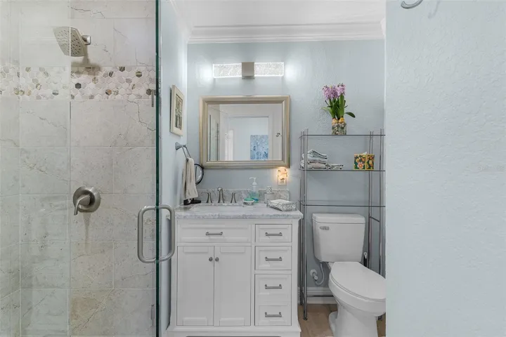 New full bath on west side of the home. It has a linen closet & tiled walk-in shower with frameless glass doors.