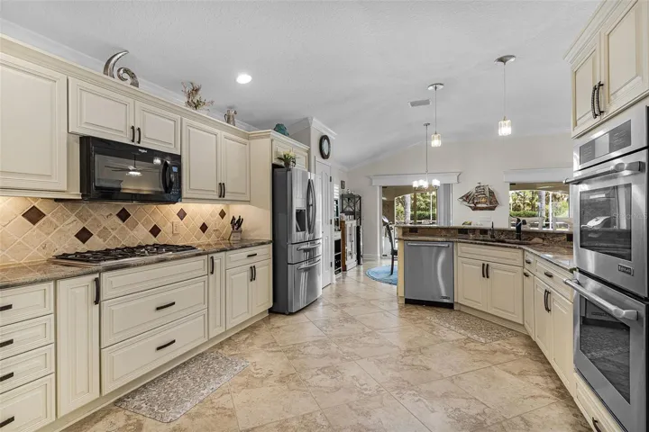 Spacious kitchen with tile backsplash & Jenn-Air Cooktop