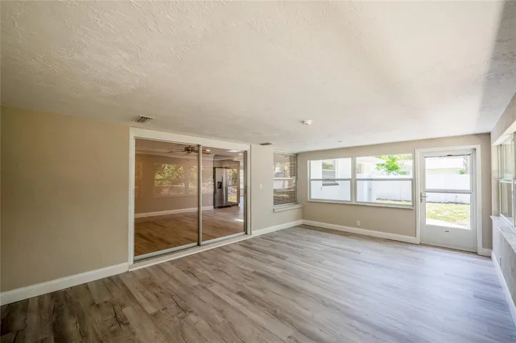 Opposite view of the sunroom highlighting the large glass sliding doors that seamlessly connect the space to the main living area.
