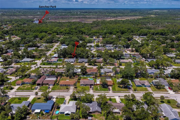 An expansive aerial view illustrating the property's proximity to the lush greenery of Sanchez Park and nearby waterways. It's an ideal location for outdoor enthusiasts who enjoy kayaking, hiking, and nature.