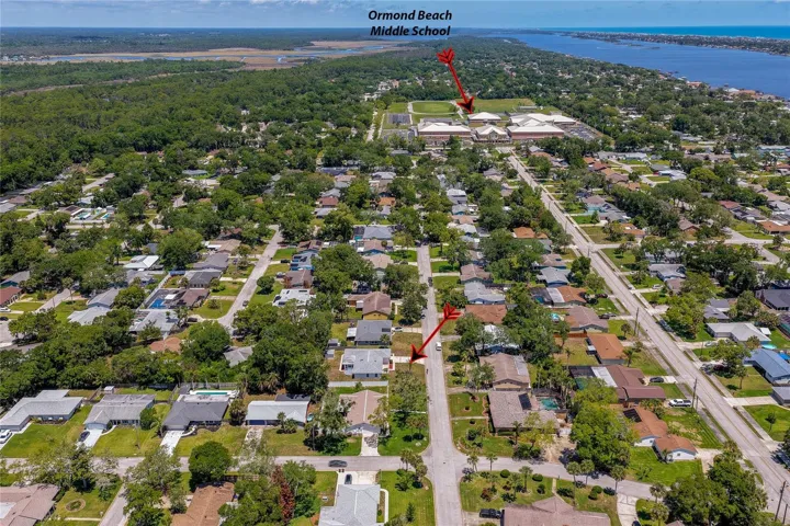 High-altitude aerial shot showcasing the home’s excellent location within a walkable coastal neighborhood, just blocks away from Ormond Beach Middle School.