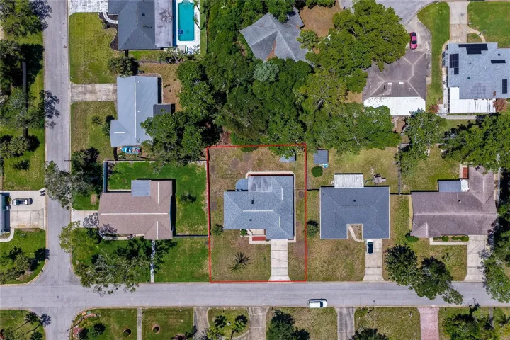 A top-down lot overview showing the property’s generous boundaries, outlined in red, amidst a peaceful residential grid. The surrounding dense canopy of mature trees offers excellent natural shade and backyard privacy.