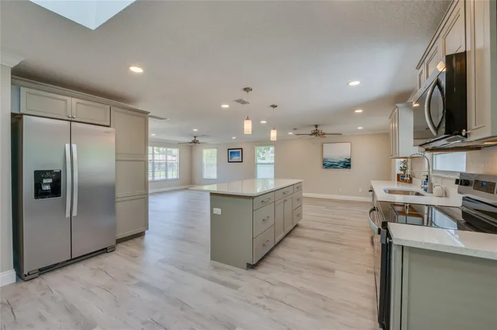 Fully equipped kitchen offering modern stainless steel appliances, sophisticated cabinetry, and a large central island with integrated storage. The layout effortlessly flows into the main living areas, keeping you connected while cooking.