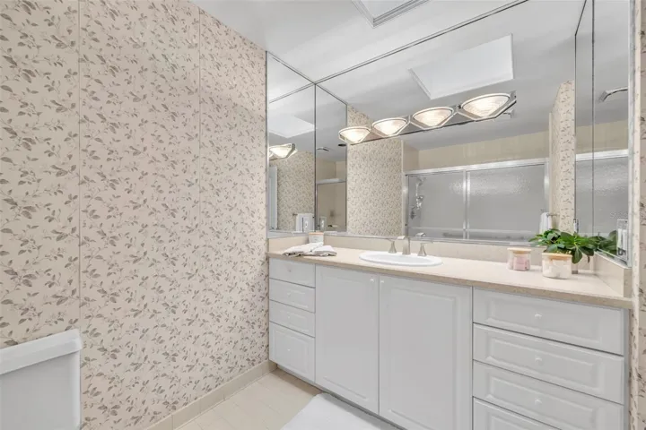 The primary bathroom offers abundant storage in a large vanity area and a full linen closet.