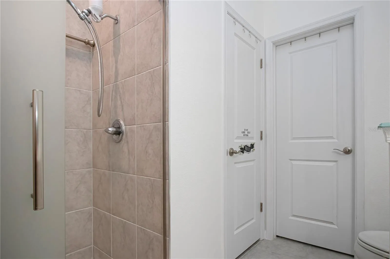 Primary Bathroom on first floor with walk-in shower and walk-in closet and linen storage