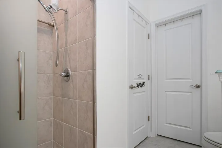 Primary Bathroom on first floor with walk-in shower and walk-in closet and linen storage