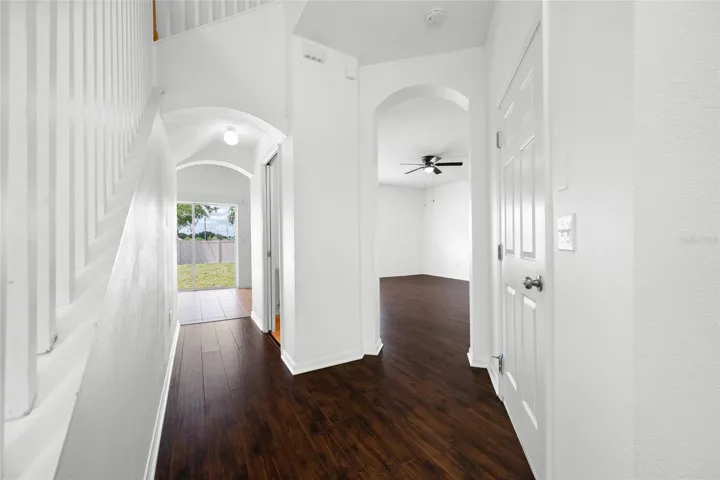 View of Hallway to Guest Half Bath to Sliding Glass Door and Door to Garage and Family Room