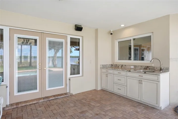 Covered Lanai and highvelocity pool enclosure withopen-view screen system,paver pool deck and PebbleTecpool offers year roundenjoyment and entertainingvirtually staged