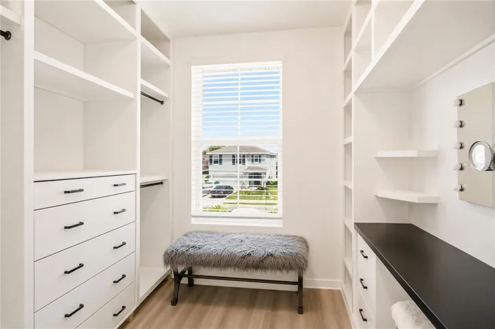 Custom wood shelving throughout walk-in owner's closet