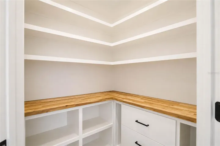 Pantry with custom wood shelving. Smart storage upgrades throughout this Evergreen Bradenton FL home