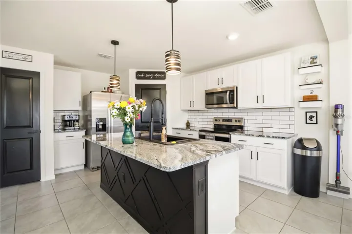 Upgraded kitchen featuring custom backsplash, paneled island, and stainless steel appliances. Evergreen, Bradenton FL