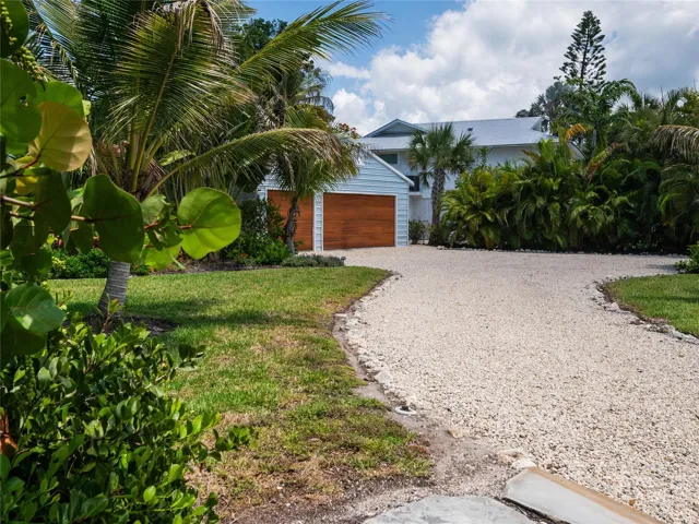 Beautifully landscaped property with gravel driveway to garage
