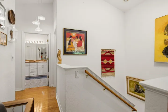 Stairs to primary bedroom/bathroom with light fixture originally from Hotel Detroit in St Petersburg.