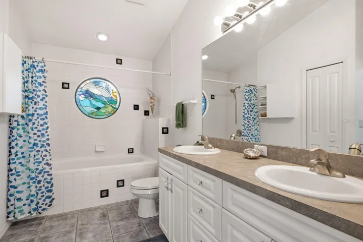 En Suite Primary bathroom with double vanity & linen closet.