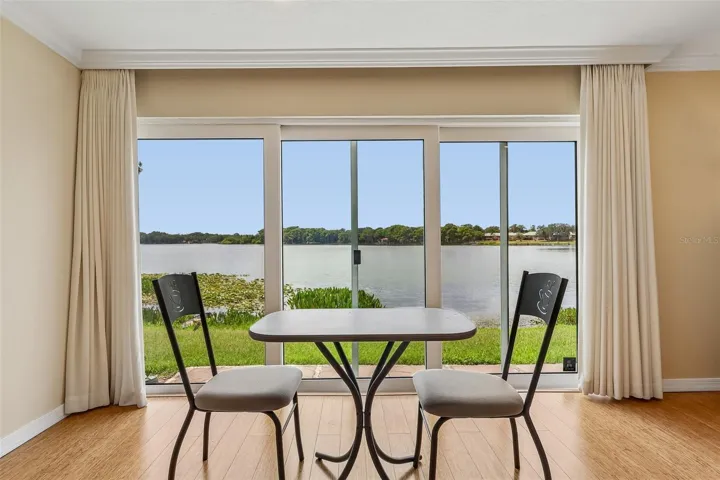 The Dining area enjoys peaceful backyard and LAKE VIEWS and features sliding glass doors that invite NATURAL LIGHT inside while enhancing the home's indoor-outdoor feel.