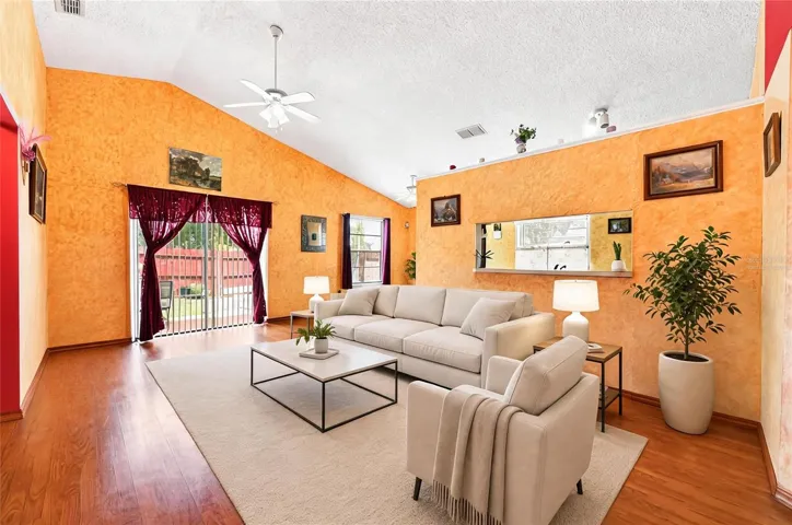 Comfortable living area has sliding glass doors access to the patio and fenced backyard. Virtually Staged.