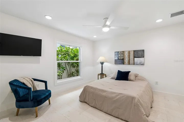 5th bedroom guest suite w/ shell stone flooring and pocket door for suite privacy,