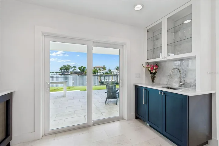 Bar/beverage area with sink and full natural stone backsplash
