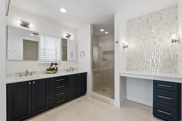 Master bath with custom cabinetry and shell mosaic tile wall