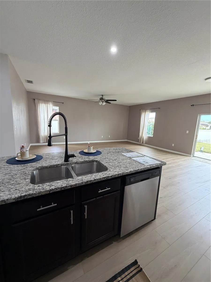 New Flooring in Large Kitchen features Oversized Granite Island Upgraded faucet and walk in pantry