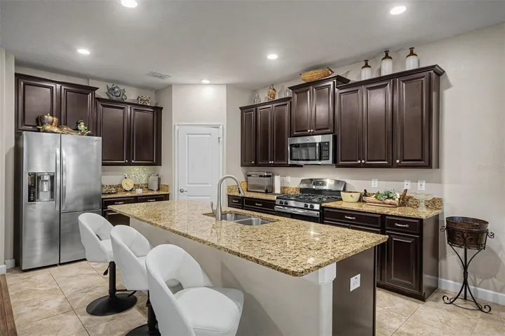 Espresso cabinets with crown molding, granite center island and counters and upgraded appliances in the gourmet kitchen!
