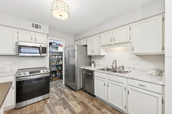 At the heart of the home, the stunning UPDATED Kitchen truly shines with crisp white cabinetry, marble-look countertops, stainless steel appliances, and a WALK-IN PANTRY CLOSET.