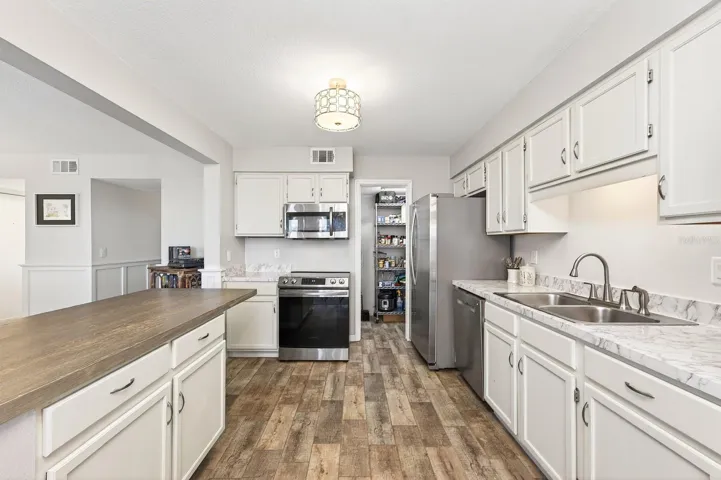 A center island with breakfast bar seating provides extra prep space and a comfortable spot for quick meals.