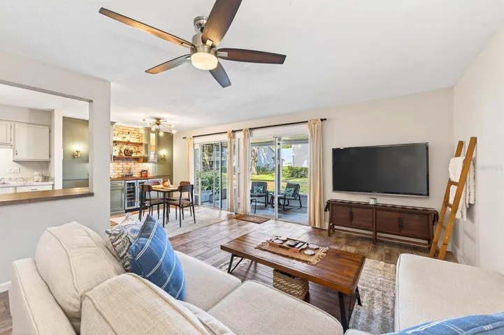 The spacious Living Room is FILLED WITH SUNLIGHT and features sliding glass doors that open to the COVERED and ENCLOSED SCREENED PATIO.