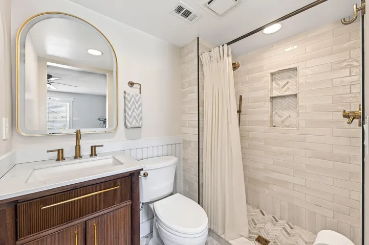The GENEROUS PRIMARY SUITE offers a relaxing private retreat, complete with a walk-in closet and beautifully UPDATED EN SUITE BATH featuring a modern vanity and sleek step-in shower.