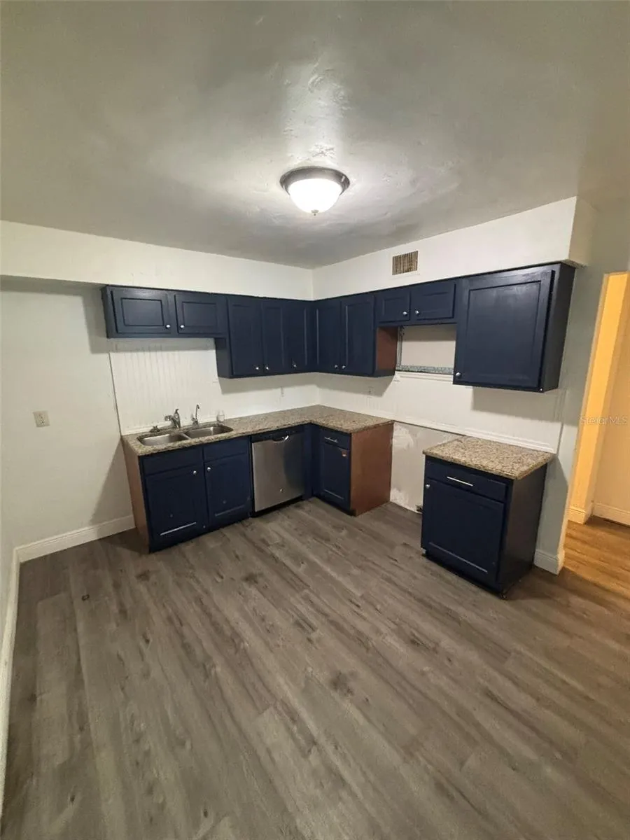 Fresh paint, vinyl flooring, and countertops in kitchen